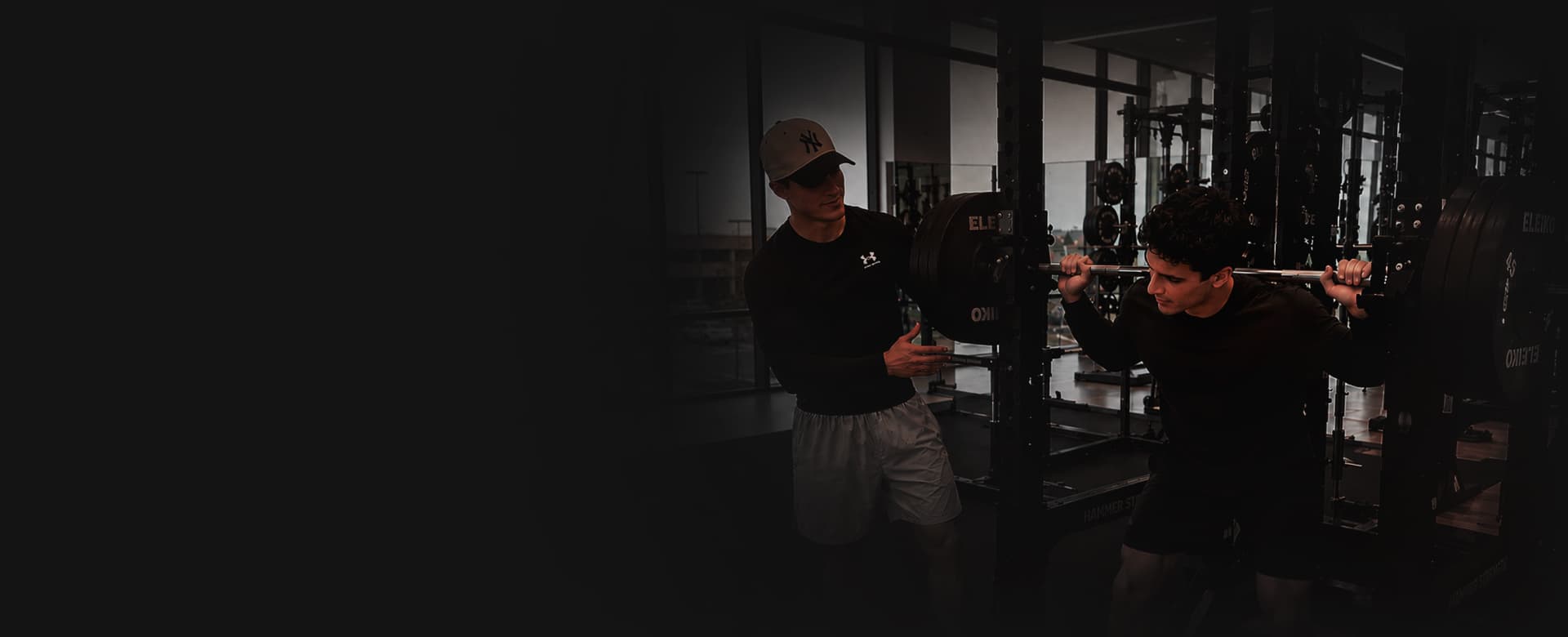 SENA coach spotting a client during a barbell squat